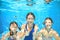 Family swims in pool under water, happy active mother and children have fun, fitness and sport