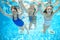 Family swims in pool under water, happy active mother and children have fun underwater, kids sport