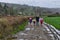 A family taking a walk along a road surrounded by farms and Welsh hills.