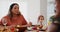 Family talking, thanksgiving dinner and home with eating, smile or relax with food in dining room. Woman, man and child