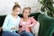 Family and technology. Aged woman and her adult daughter using smartphone at home.