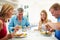 Family With Teenage Children Eating Meal At Home Together