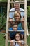 Family  in their garden, posing on a ladder