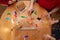 Family of three decorating home baked gingerbread houses with colorful sweet pastilles and sparkling glitter