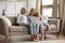 Family of three diverse age female members resting with laptop