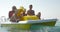 Family of three enjoying water ride on pedal boat