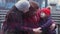 Family of three generations of smiling women sitting on a bench in the city park and embracing. Family concept. Mother`s