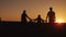 A family of three goes forward at sunset