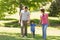 Family of three holding hands and walking at park