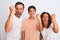 Family of three, mother, father and son standing over white isolated background angry and mad raising fist frustrated and furious