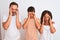 Family of three, mother, father and son standing over white isolated background with hand on head for pain in head because stress