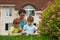 Family of three people on lawn in front of house