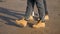 Family three people walking on the sand in warm shoes