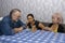 A family of three is playing a board game at a table. Elderly people develop logical thinking, leisure for pensioners, home entert