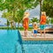 Family of three by poolside. Resort swimming pool at Seychelles