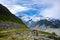 A family of three tourists is watching Panorama view the mueller glacier