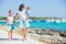 Family of three walking along tropical beach