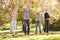 Family Throwing Autumn Leaves In The Air