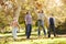 Family Throwing Autumn Leaves In The Air