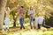 Family Throwing Autumn Leaves In The Air