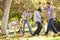 Family Throwing Autumn Leaves In The Air