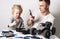 Family time: Daughter with father repairs a radio-controlled buggy model. Dad shoots a repair process on his smartphone.