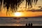 Family of tourists sitting on the beach watching the beautiful Hawaiian sunset