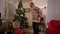 Family Traditions, Elderly Man and Kid Have Fun on Christmas Eve. Grandfather and grandson Toddler dance around the