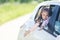 Family travel concept by car. Happy smiling child girl looking from the car window. Summer background. Soft focus