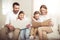 Family with two adorable children sitting together and reading books at home