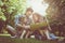 Family with two children in meadow reading book together.