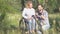 A family of two people a woman in a wheelchair poses for the husband of a photographer in nature. A couple in the middle