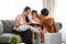 Family using digital tablet. Parents showing digital tablet to their daughter on couch.