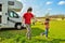 Family vacation, RV travel with kids, happy father with child has fun on family holiday trip in motorhome, camper exterior