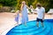 Family vacation in summer. Parents with kid having fun near swimming pool