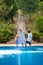 Family vacation in summer. Parents with kid having fun near swimming pool