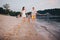 Family vacation in summer. Young Caucasian family foot walking barefoot sandy beach, shore river water. Dad mom holding hands two