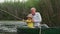 family vacations in river, elderly caring grandfather with little grandson on boat while relaxing in countryside