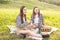 Family value. Two sisters in the Park on the grass met, look into the distance, have fun