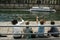 Family waiving at a typical tourist ship `Bateau Mouche` cruising on Seine river, near Ile de la Cite.