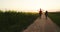 Family walking along a farm at sunset, bonding and having fun in nature. Agriculture, happy family and peaceful walk