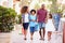 Family Walking Along Street With Shopping Bags