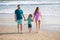 Family walking on beach. Mother father and child son spending time together. Family summer vacation. Parent dad mom