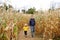 Family walking among the dried corn stalks in a corn maze