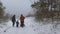 Family walking forest trail to the beach in winter