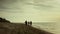 Family walking morning beach. Young people running on empty sunrise seashore.