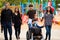 Family walking past playground with disabled son in wheelchair