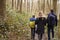 Family walking together through a wood, back view close up