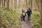 Family walking through a wood, back view, mum turning round