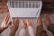 Family warming hands near electric heater at home, closeup